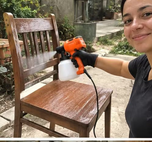 Mujer pintando una silla de madera con la pistola de pintura