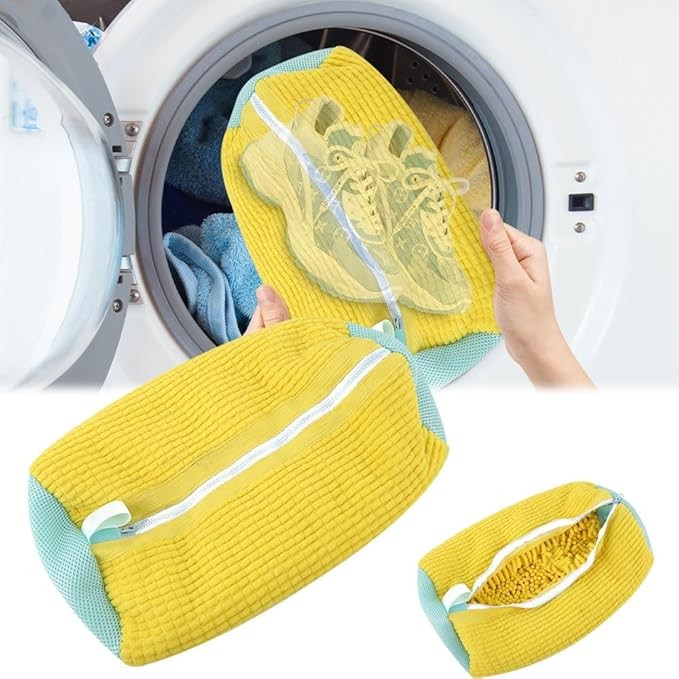 Bolsa amarilla de chenilla para lavar zapatos, abierta con un tenis dentro, junto a una lavadora