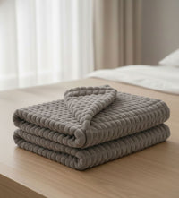 Cobija decorativa color gris sobre mesa