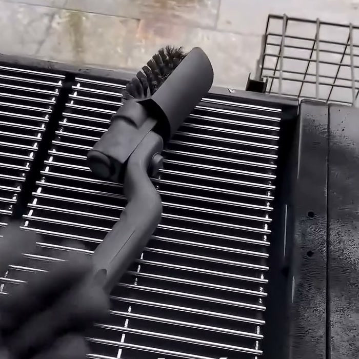 Cepillo eléctrico con la cabeza girada sobre una rejilla de parrilla limpia