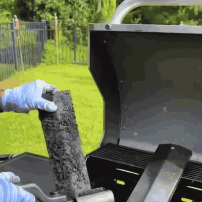 Cepillo eléctrico quitando la grasa carbonizada de una barra de parrilla de gas