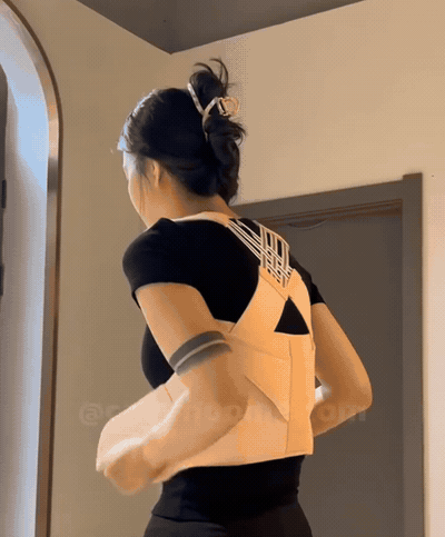 Mujer colocándose y ajustando el corrector de postura en casa