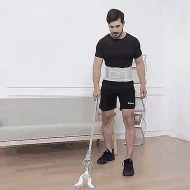 Hombre con la faja lumbar gris barriendo, levantando una mesa y entrenando con pesas