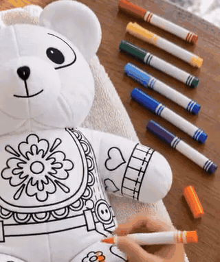 Marcador naranja rellenando el diseño del peluche de oso